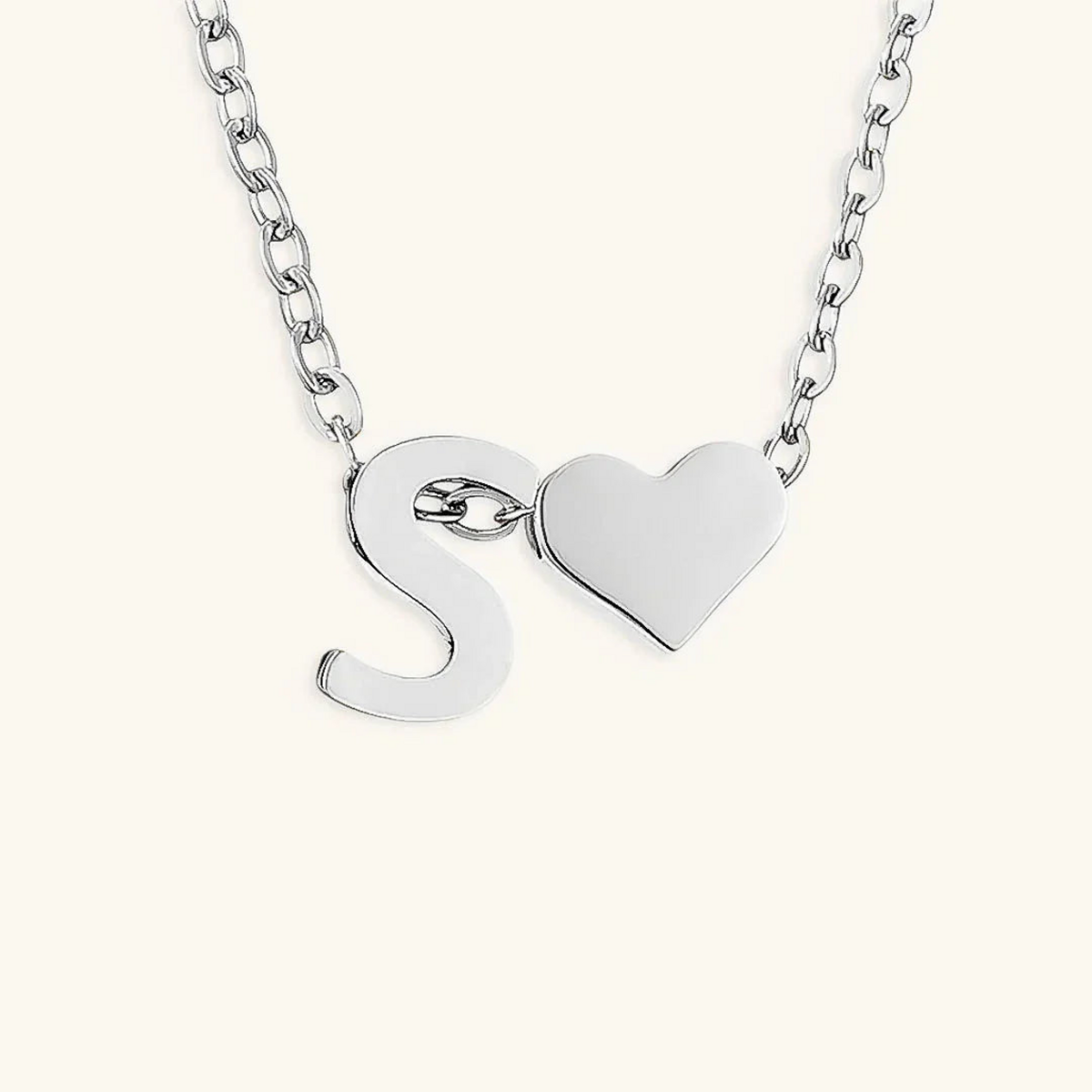 Seraya silver-tone initial S and heart necklace on an ivory background