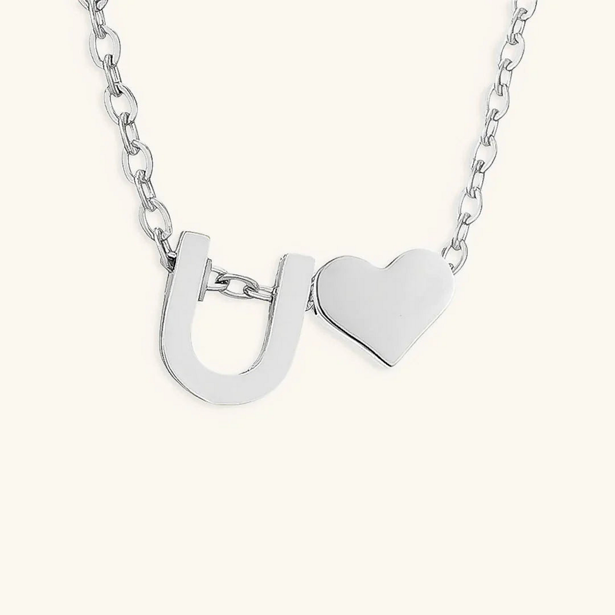 Seraya silver-tone initial U and heart necklace on an ivory background
