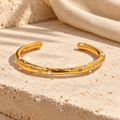 Coravelle open gold cuff with scattered freshwater pearls and clear round stones
