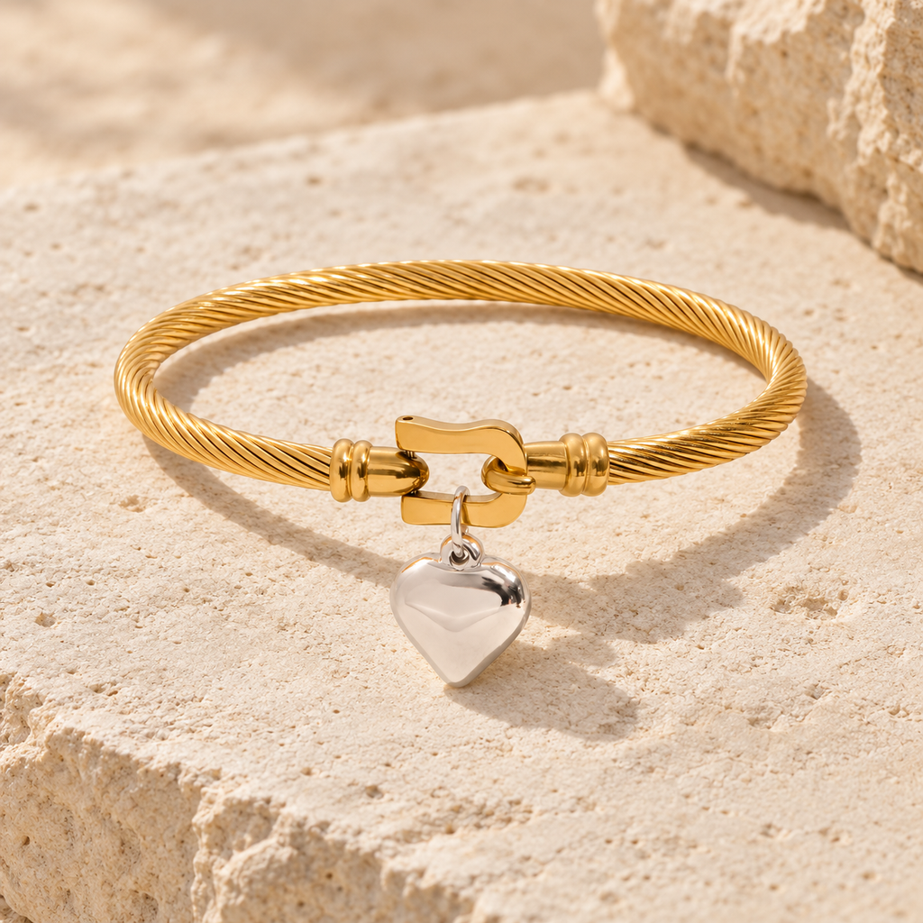 Elunara twisted gold cable bracelet with central clasp and polished silver heart