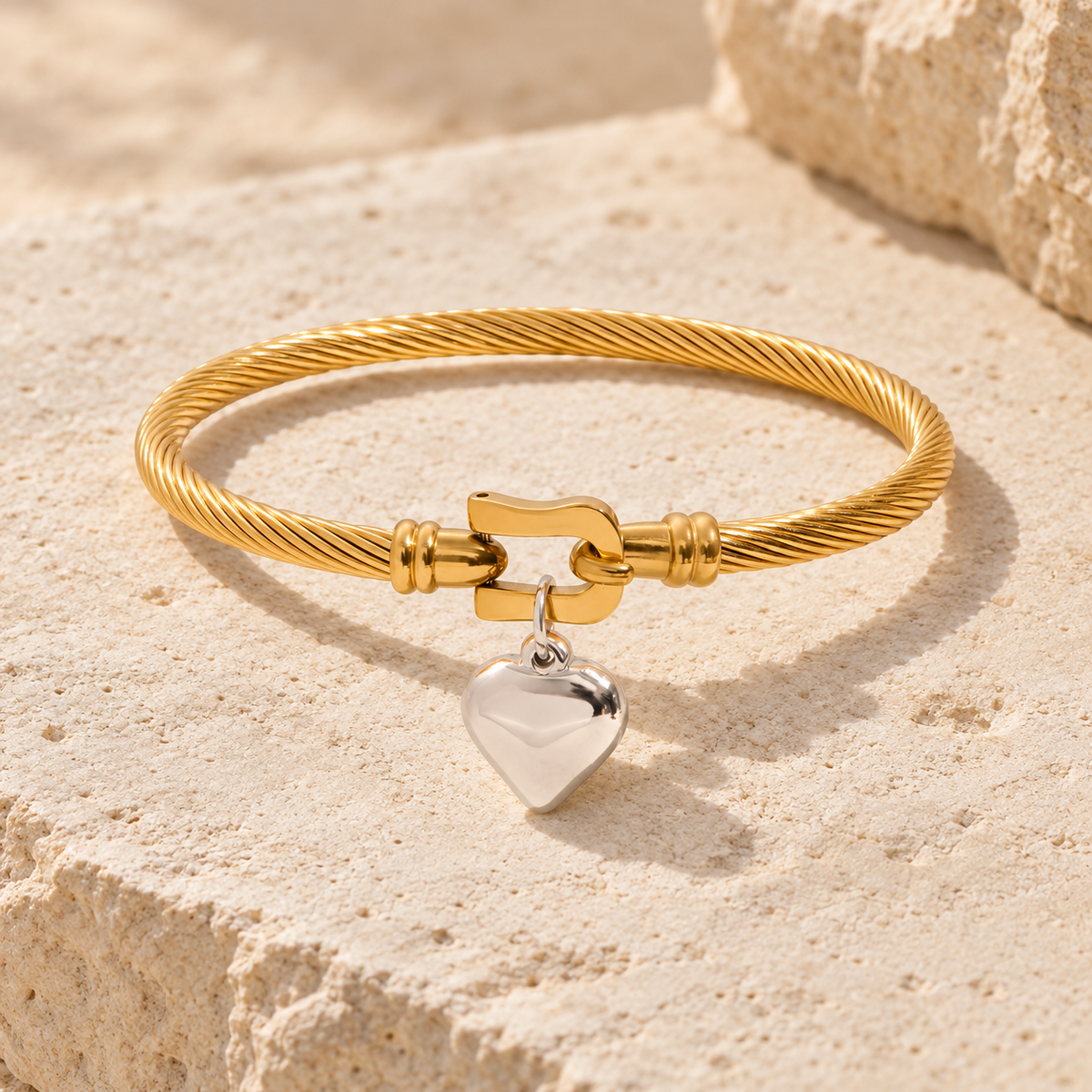 Elunara twisted gold cable bracelet with central clasp and polished silver heart