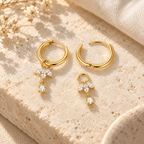 Liorenne hinged hoops showing one attached charm and one removed charm